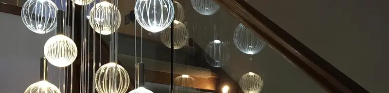 Cluster of decorative glass globe pendant lights hanging beside a staircase